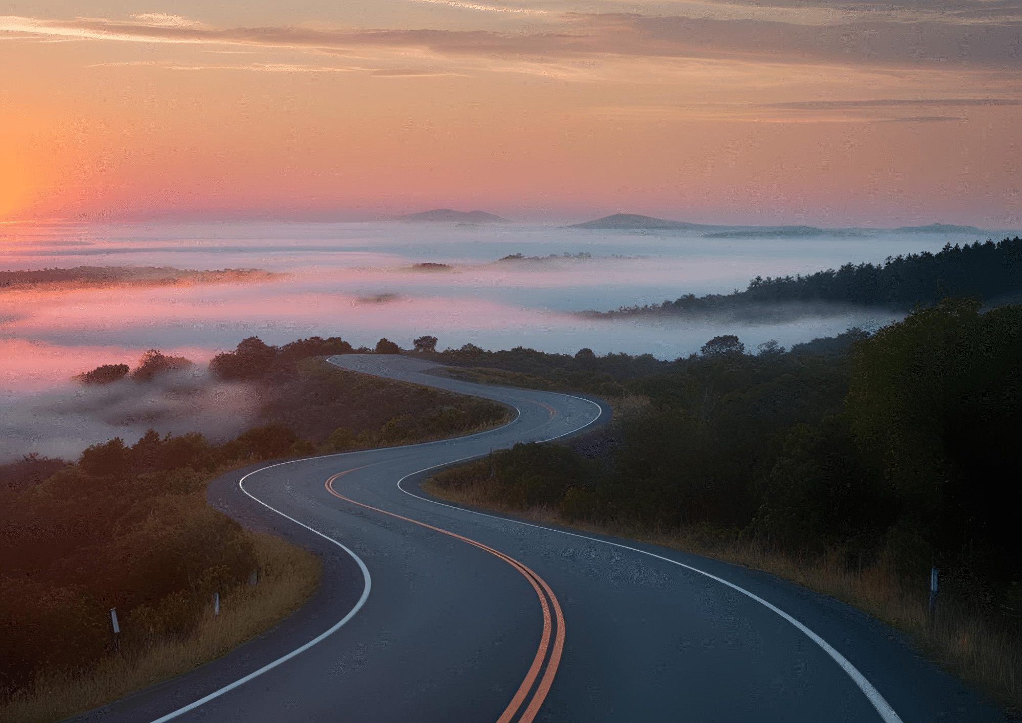 Une route sinueuse dans la nature représentant le changement avec une brume au loin illustrant l'inconnu et l'incertitude.